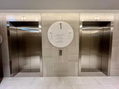two elevators in a building with a clock on the wall at Downtown Views 1BR - Dubai Mall, Fountain & Burj Khalifa access in Dubai