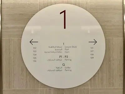 a white clock on a wall with numbers on it at Downtown Views 1BR - Dubai Mall, Fountain & Burj Khalifa access in Dubai