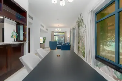 a dining room with a long table and chairs at Lux BnB Travo Tower I Private Garden I Lake View in Dubai