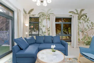 a living room with a blue couch and a table at Lux BnB Travo Tower I Private Garden I Lake View in Dubai