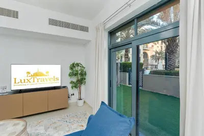 a living room with a large sliding glass door at Lux BnB Travo Tower I Private Garden I Lake View in Dubai