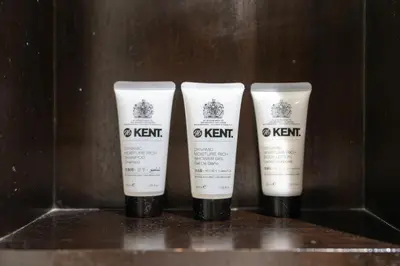 three bottles of kent products sitting on a shelf at Lux BnB Travo Tower I Private Garden I Lake View in Dubai