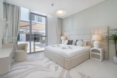 a bedroom with a bed and a couch and a chair at Crystal water lagoon living in District One in Dubai