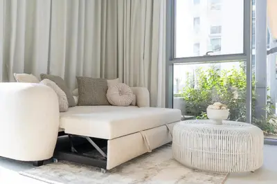 a living room with a couch and a chair and a table at Crystal water lagoon living in District One in Dubai