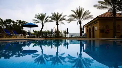 a swimming pool with palm trees and a building at Studio sea view in Dubai