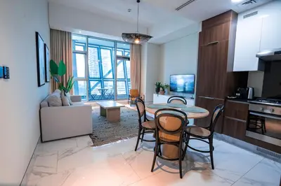 a kitchen and living room with a table and chairs at Elegant 1bedroom in J ONE in Dubai