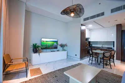 a living room with a tv and a table at Elegant 1bedroom in J ONE in Dubai