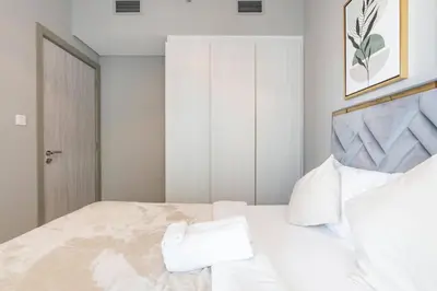 a bedroom with a large white bed with white pillows at The View 1 Bedroom in Dubai