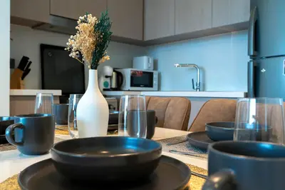 a table with plates and a vase with flowers on it at White Sage - Act One Tower in Dubai