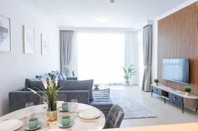 a living room with a table and a couch and a tv at Al Bateen Resdences by HAPPY SEASON JBR in Dubai