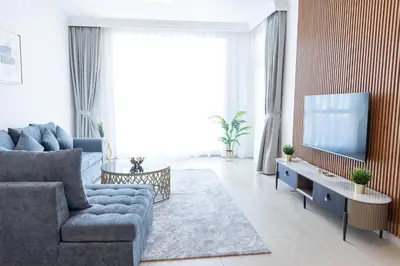 a living room with a couch and a tv at Al Bateen Resdences by HAPPY SEASON JBR in Dubai
