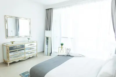 a bedroom with a bed and a mirror and a dresser at Al Bateen Resdences by HAPPY SEASON JBR in Dubai