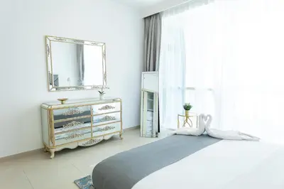 a bedroom with a bed and a mirror and a dresser at Al Bateen Resdences by HAPPY SEASON JBR in Dubai