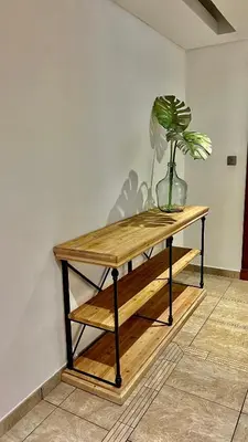 a plant in a vase sitting on a wooden table at Direct Access to Nakheel Mall At the Heart of The Palm in Dubai
