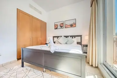 a bedroom with a large white bed and a window at Direct Access to Nakheel Mall At the Heart of The Palm in Dubai