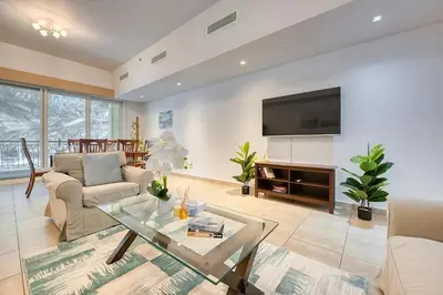 a living room with a couch and a tv at Direct Access to Nakheel Mall At the Heart of The Palm in Dubai