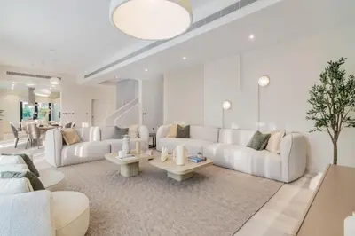 a living room with white couches and tables at Stunning Palm Villa with Rooftop Garden, Resort Style Pool and Beach by Exclusive Holiday Homes in Dubai