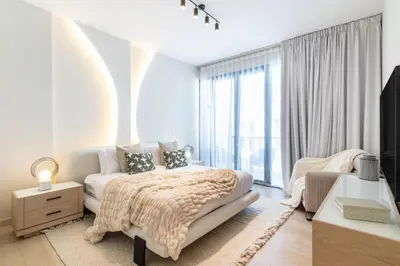 a white bedroom with a bed and a large window at Stunning Palm Villa with Rooftop Garden, Resort Style Pool and Beach by Exclusive Holiday Homes in Dubai