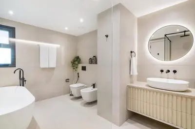 a bathroom with a sink and a toilet and a mirror at Stunning Palm Villa with Rooftop Garden, Resort Style Pool and Beach by Exclusive Holiday Homes in Dubai