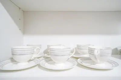 a group of white cups and saucers on a shelf at New Arabian 2 Bedroom J One Tower Business Bay in Dubai