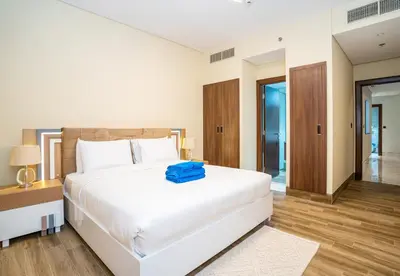 a bedroom with a large white bed and a wooden floor at New Arabian 2 Bedroom J One Tower Business Bay in Dubai