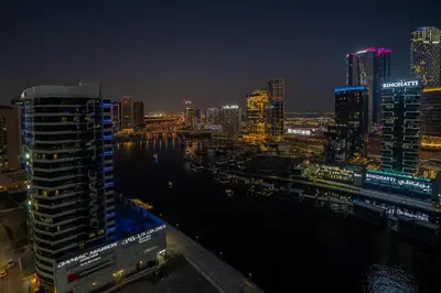 a city skyline at night with a river and buildings at New Arabian 2 Bedroom J One Tower Business Bay in Dubai