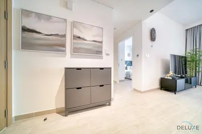 a living room with a white wall with two paintings at Capacious 2BR at Sunset at Creek Beach 3 Dubai Creek Harbor by Deluxe Holiday Homes in Dubai