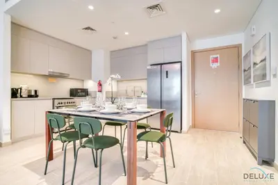 a kitchen with a table and chairs in a kitchen at Capacious 2BR at Sunset at Creek Beach 3 Dubai Creek Harbor by Deluxe Holiday Homes in Dubai