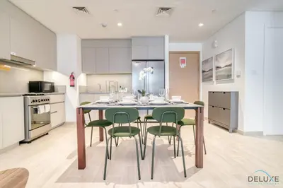 a kitchen with a dining table and green chairs at Capacious 2BR at Sunset at Creek Beach 3 Dubai Creek Harbor by Deluxe Holiday Homes in Dubai