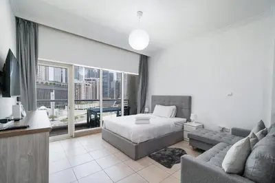 a bedroom with a bed and a couch and a large window at Studio close to Burj Khalifa and Downtown Dubai in Dubai