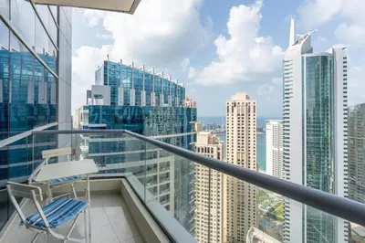 a chair on a balcony with a view of a city at Perfect 2BD apartment in the heart of Marina - top spot in Dubai