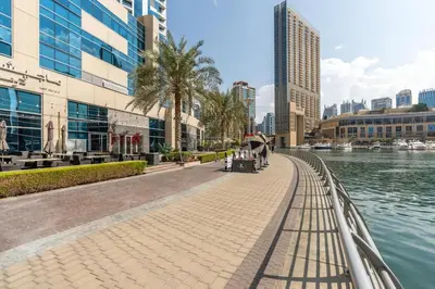 a walkway next to a river in a city at Perfect 2BD apartment in the heart of Marina - top spot in Dubai