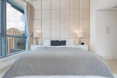 a bedroom with a large bed and a large window at Perfect 2BD apartment in the heart of Marina - top spot in Dubai