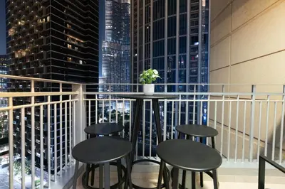 a balcony with tables and stools and a view of a city at Burj Khalifa Views / 5 min walk from Dubai Mall / Dubai Opera / Upgraded / Designer Choice / 8 people / The Best Location in Dubai
