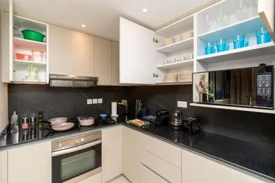 a kitchen with white cabinets and black counter tops at Burj Khalifa Views / 5 min walk from Dubai Mall / Dubai Opera / Upgraded / Designer Choice / 8 people / The Best Location in Dubai