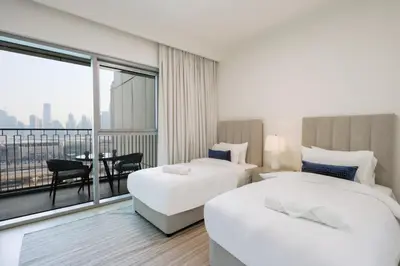 a hotel room with two beds and a balcony at Livbnb Suites - Lavish 2BR w/ Burj Khalifa Views & Near Dubai Mall in Dubai