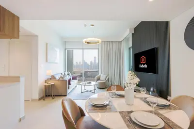 a dining room and living room with a table and chairs at Livbnb Suites - Lavish 2BR w/ Burj Khalifa Views & Near Dubai Mall in Dubai