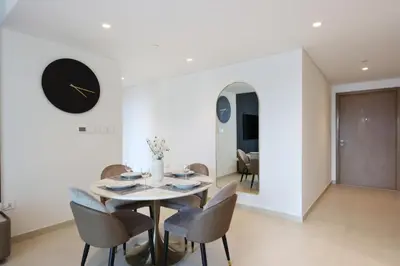a dining room with a table and chairs and a clock at Livbnb Suites - Lavish 2BR w/ Burj Khalifa Views & Near Dubai Mall in Dubai