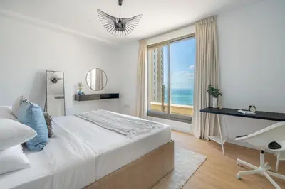 a bedroom with a bed and a desk and a window at GuestReady - Seaview residence in Dubai Marina in Dubai