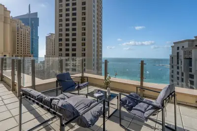 a balcony with chairs and a view of the ocean at GuestReady - Seaview residence in Dubai Marina in Dubai