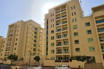 two tall buildings with cars parked in front of them at Modern-Chic 1BR in The Greens - Central Dubai in Dubai