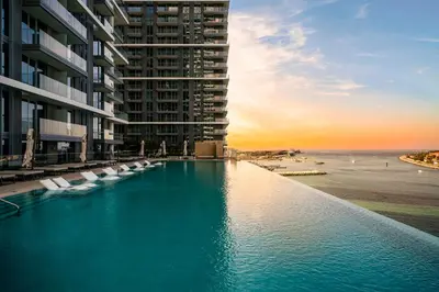 a swimming pool with chairs in front of a building at *Private Beach* Best Ocean View Emaar BeachFront in Dubai