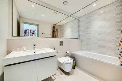 a bathroom with a sink and a tub and a toilet at Emaar Beachfront Sunrise Bay 2bdr apartment in Dubai