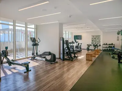 a gym with treadmills and exercise equipment in a room at Emaar Beachfront Sunrise Bay 2bdr apartment in Dubai