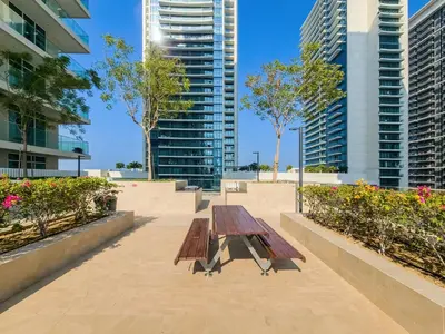 a picnic table in a park with tall buildings at Emaar Beachfront Sunrise Bay 2bdr apartment in Dubai