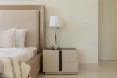 a lamp on a night stand next to a bed at Emaar Beachfront Beach Vista 3bdr apartment in Dubai