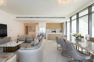 a living room and kitchen with a dining table and chairs at Emaar Beachfront Beach Vista 3bdr apartment in Dubai