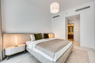 a bedroom with a bed and a nightstand with a lamp at Phenomenal 2BD with the beach in Dubai