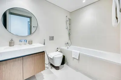 a bathroom with a sink and a toilet and a mirror at Phenomenal 2BD with the beach in Dubai