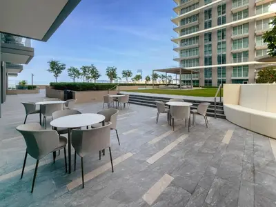 a patio with tables and chairs in a building at Phenomenal 2BD with the beach in Dubai
